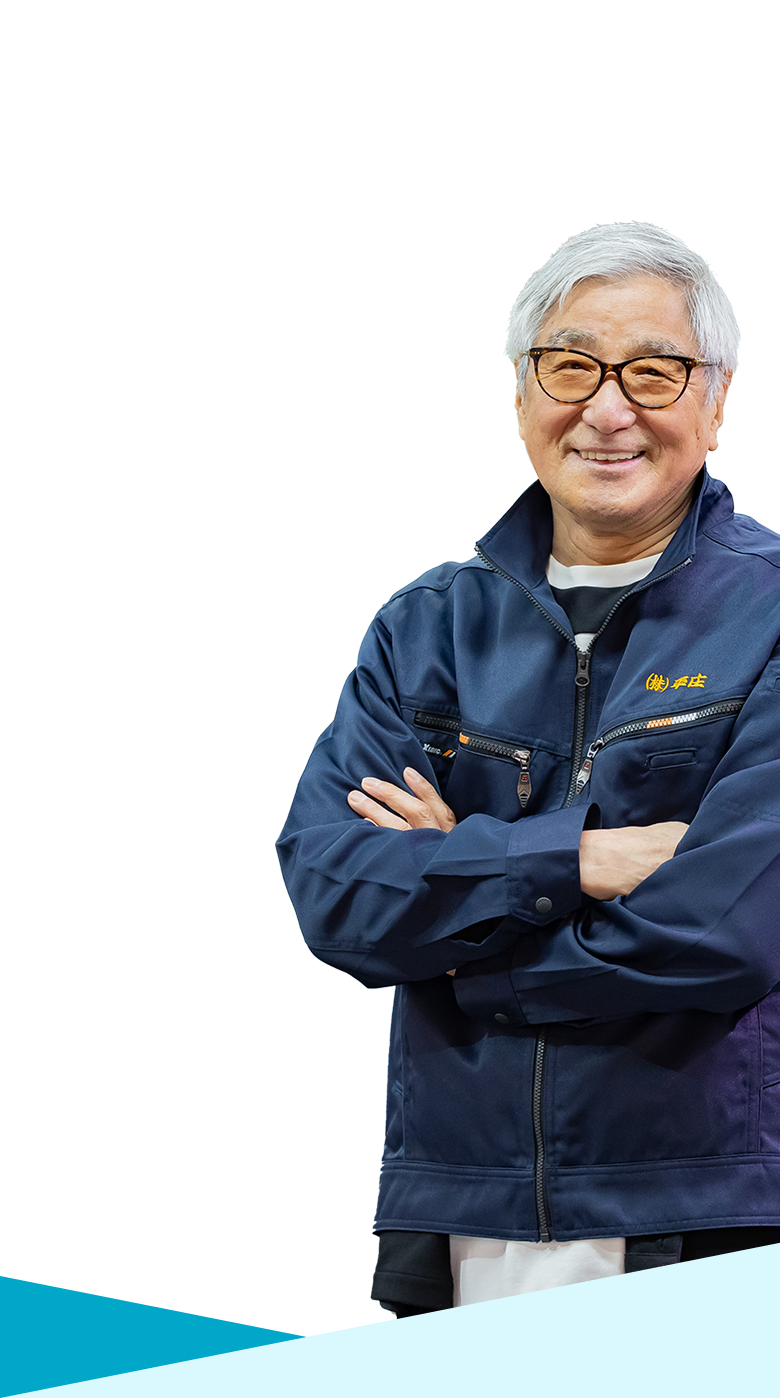 魚市場で腕を組んで微笑んでいる男性の様子