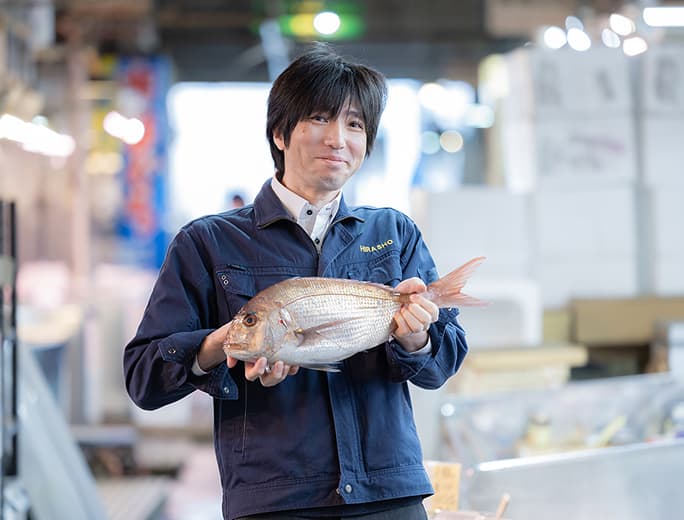 従業員が魚を持っている様子