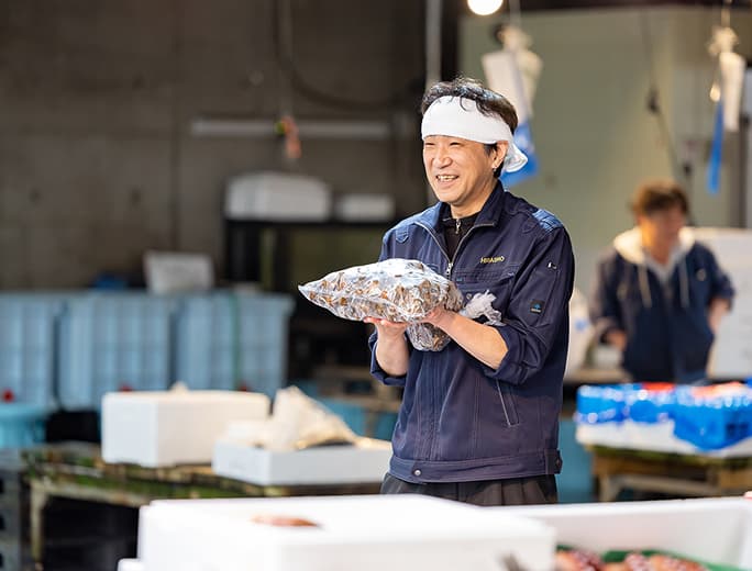 従業員が魚を持っている様子